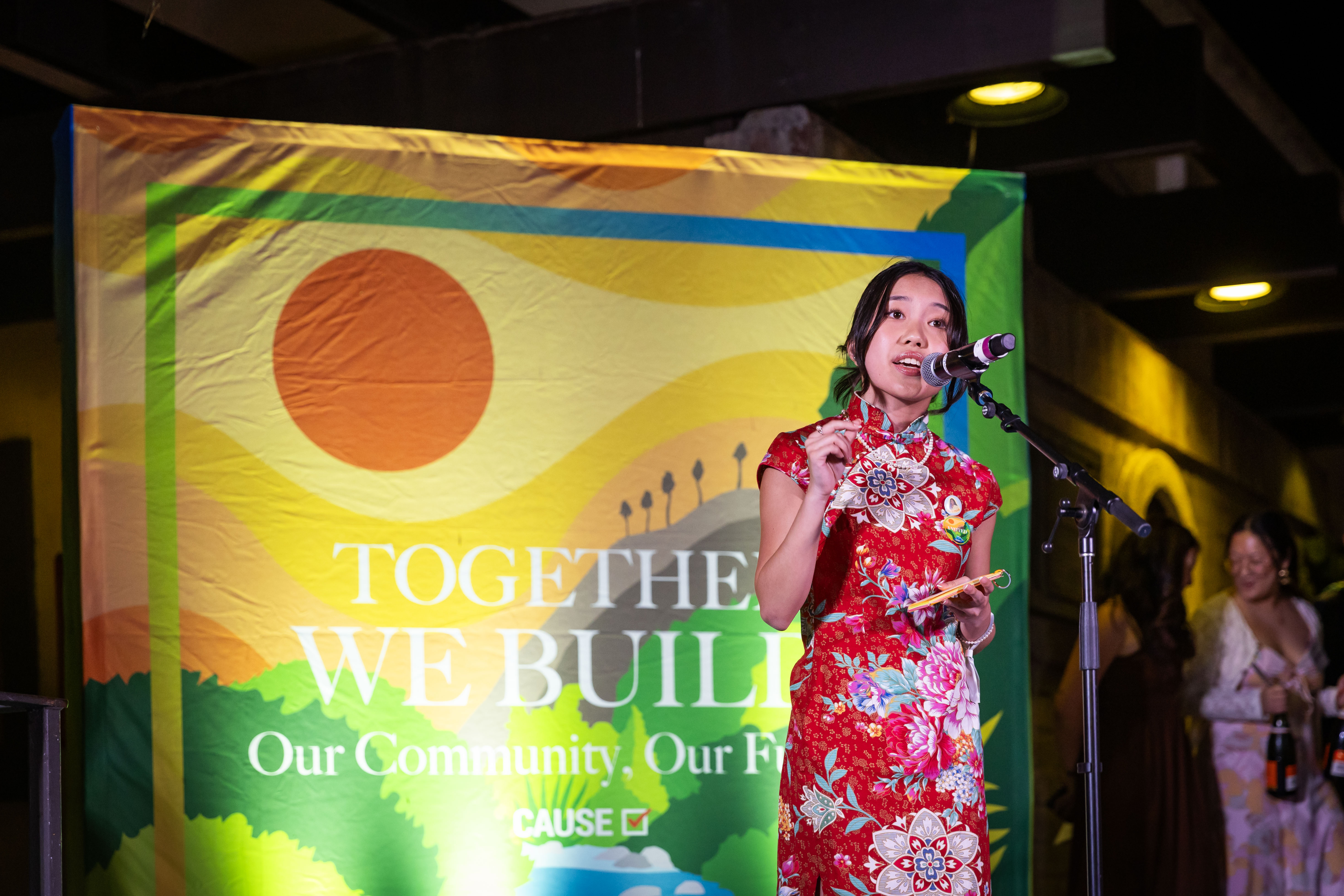 Esther speaking at a microphone