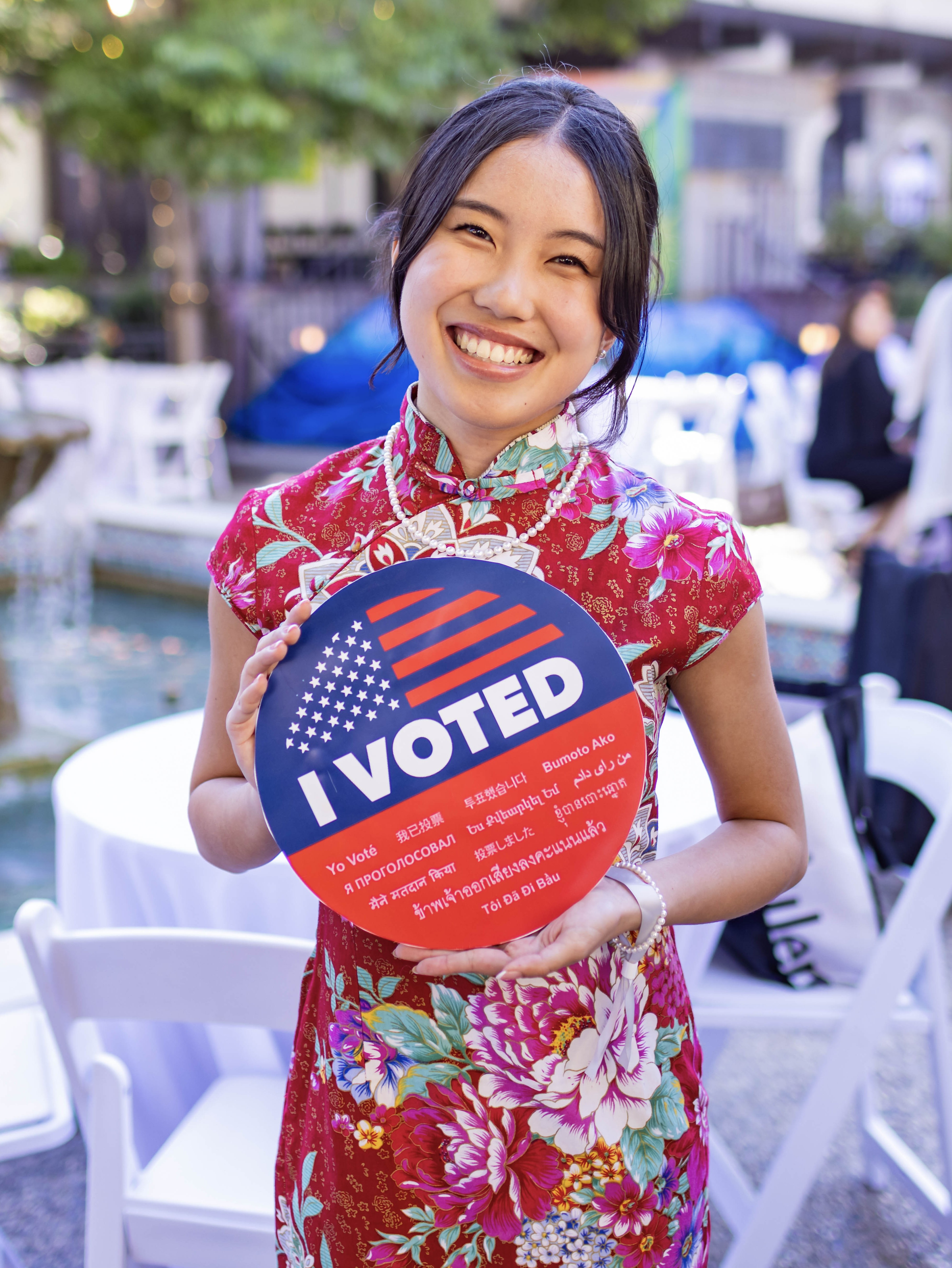 Esther Lian smiling and holding a "I Voted" sign