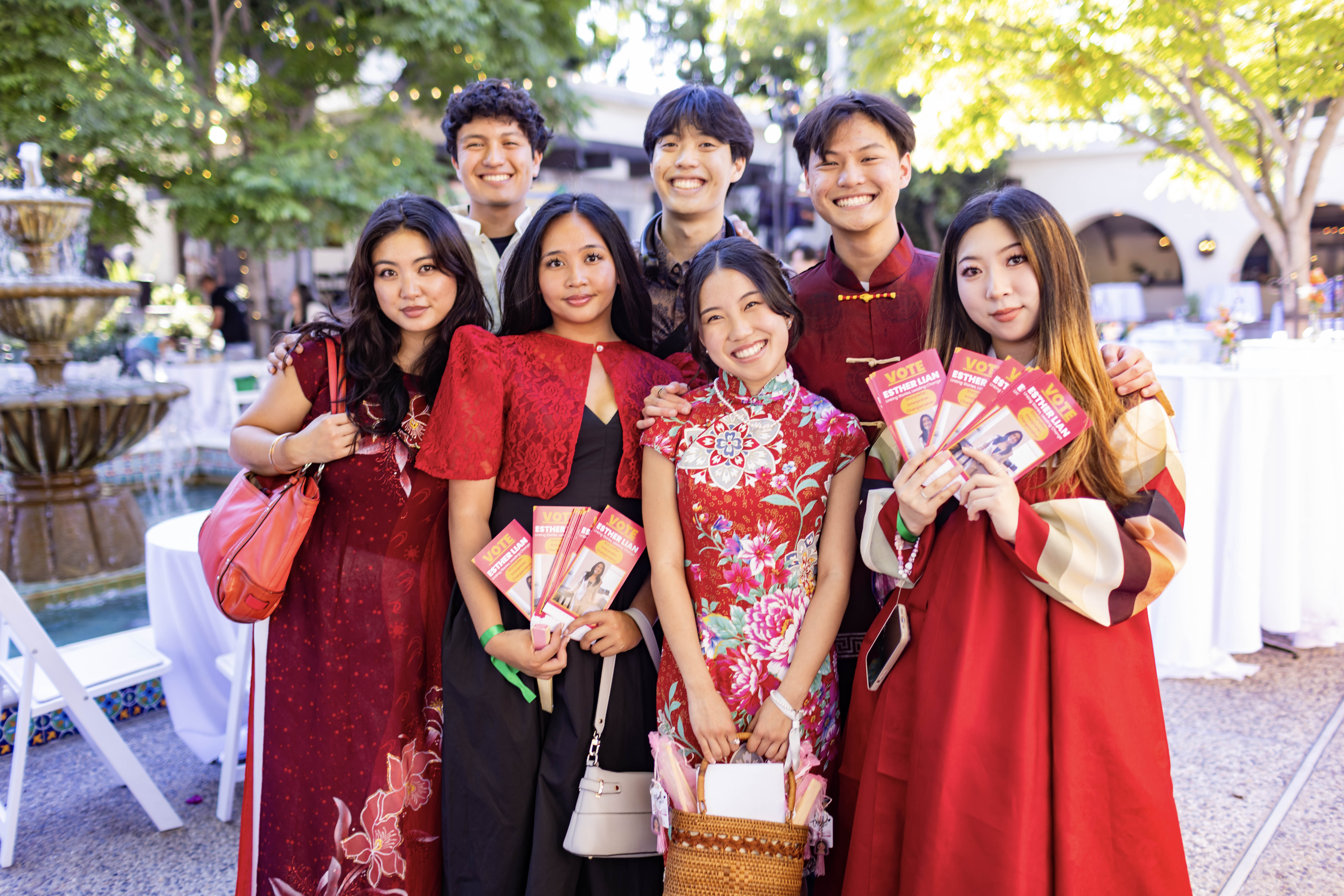 Esther surround by other Asian young people wearing red at an event